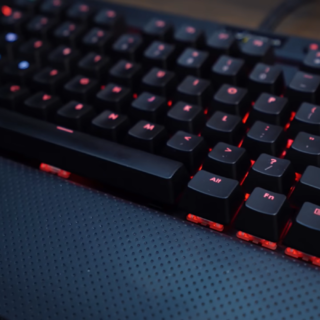 black keyboard with a red light on the black carpet