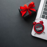 Clock on Laptop with a Gift Box Near